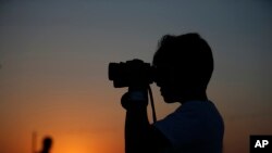 一名男子用望遠鏡在土耳其和敘利亞邊境城市遠望土耳其空襲伊斯蘭國目標。