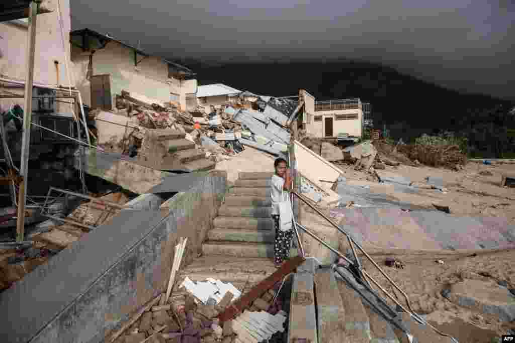 2018年9月18日，台风之后，香港石澳沿海村庄的海滩附近的学校，一名妇女站在倒塌的建筑物前。