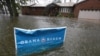 A campaign sign rises above floodwaters as rain continues falling in Norfolk, VA, Oct. 29, 2012.