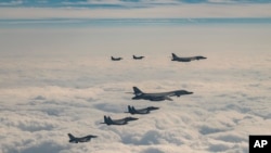 ເຮືອ​ບິນ​ຂອງ​ສະ​ຫະ​ລັດ ເກົາ​ຫຼີ​ໃຕ້ ແລະ​ຍີ່​ປຸ່ນ ບິນ​ຜ່ານ​ເກາະ​ເຈ​ຈູ ທາງ​ພາກ​ໃຕ້​ຂອງ​ເກົາ​ຫຼີ​ໃຕ້ ເມື່ອ​ວັນ​ທີ 20 ທັນ​ວາ 2023. ສະ​ຫະ​ລັດ​ໄດ້​ສົ່ງ​ເຮືອ​ບິນ​ຖິ້ມ​ລະ​ເບີດ​ໄລ​ຍະ​ໄກ ໄປ​ຮ່ວມ​ການ​ຝຶກ​ຊ້ອມ ກັບ​ເກົາ​ຫຼີ​ໃຕ້​ແລະ​ຍີ່​ປຸ່ນ. (South Korea Defense Ministry via AP)