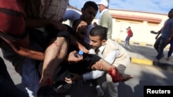 2013年11月15日，利比亚民兵在的黎波里向示威人群开枪之后，人们抢救受伤的抗议人士。