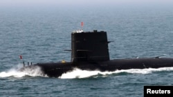 中俄在黄海举行联合海军军演期间，中国水手站在潜艇上敬礼致意。 （资料照片 2012年4月26日）