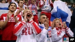 普鲁申科（前左一）2月9日在索契冬奥会上为利普尼茲卡雅的比赛加油