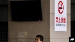 一名中国男子在北京一处明令禁止吸烟的公车站吸烟