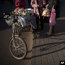 北京人向骑车的小贩买苹果