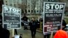 FILE - Demonstrators hold banners as they protest in opposition of President-elect Donald Trump, at McPherson Square, in Washington, Jan. 14, 2017. 