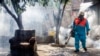 FILE - A city worker sprays insecticide to combat the Aedes aegypti mosquitoes that transmit the Zika virus, at the San Judas Community in San Salvador, El Salvador, Jan. 26, 2016.