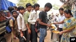 2012年1月10号在一所政府开设的高中里，一位老师在为学生分午餐。