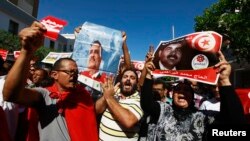 9月26日，突尼斯抗议民众在突尼斯城西南270公里的一个城市举行抗议，举着被暗杀的反对派领导人的肖像