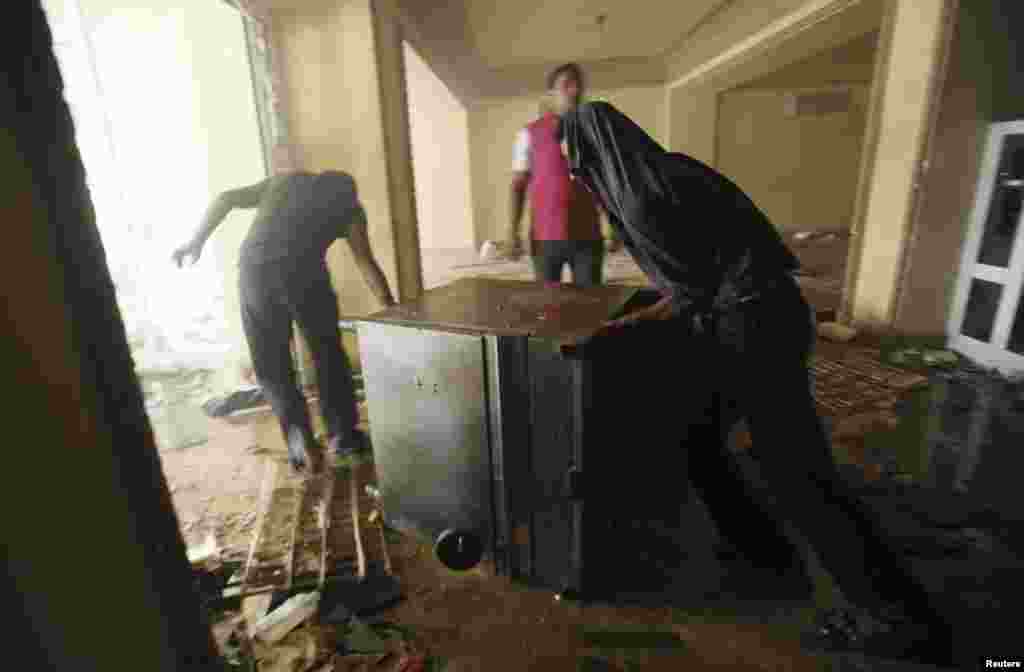 2013年7月1日，抗议者焚烧了穆斯林兄弟会在开罗穆卡塔姆区的总部后，趁火打劫者把一台炉灶拖走。