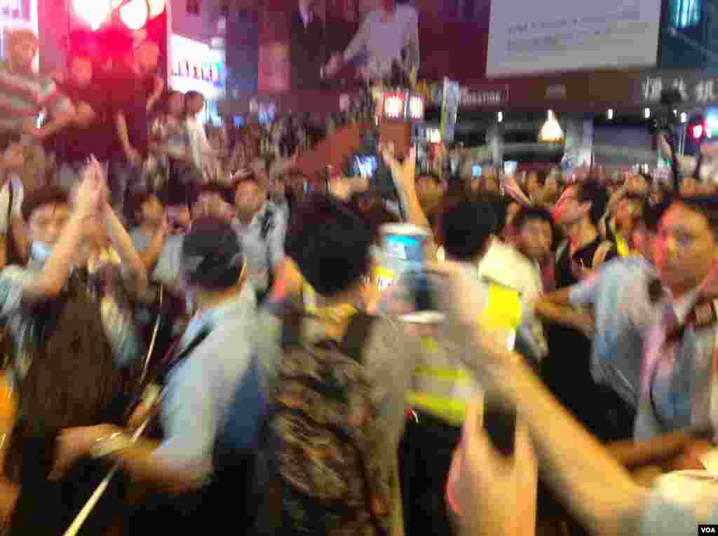 被指控欧打示威者的反占中人士被声援学生市民包围并被警方护送离开现场(美国之音海彦拍摄)