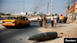 8月一日巴勒斯坦民眾圍觀一枚沒有爆炸的以色列炸彈落在加莎的主路上。