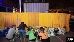 在黃色欄板被拆除前，鄭州市民前往地鐵5號線沙口路站口獻花悼念水災死難者。（2021年7月26日）