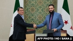 敘利亞臨時總統沙拉(右)與敘利亞民主力量指揮官阿卜迪在簽署協議後握手。 (2025年3月10日)