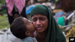 FILE - A Rohingya Muslim child kisses his mother as they rest after having crossed over from Myanmar to the Bangladesh side of the border near Cox's Bazar's Teknaf area, Sept. 2, 2017. Tens of thousands of others crossed into Bangladesh in a 24-hour span as they fled violence in western Myanmar, the UNHCR said. 