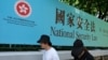 资料照：行人走过香港街头港版国安法的宣传牌。（2020年7月15日）