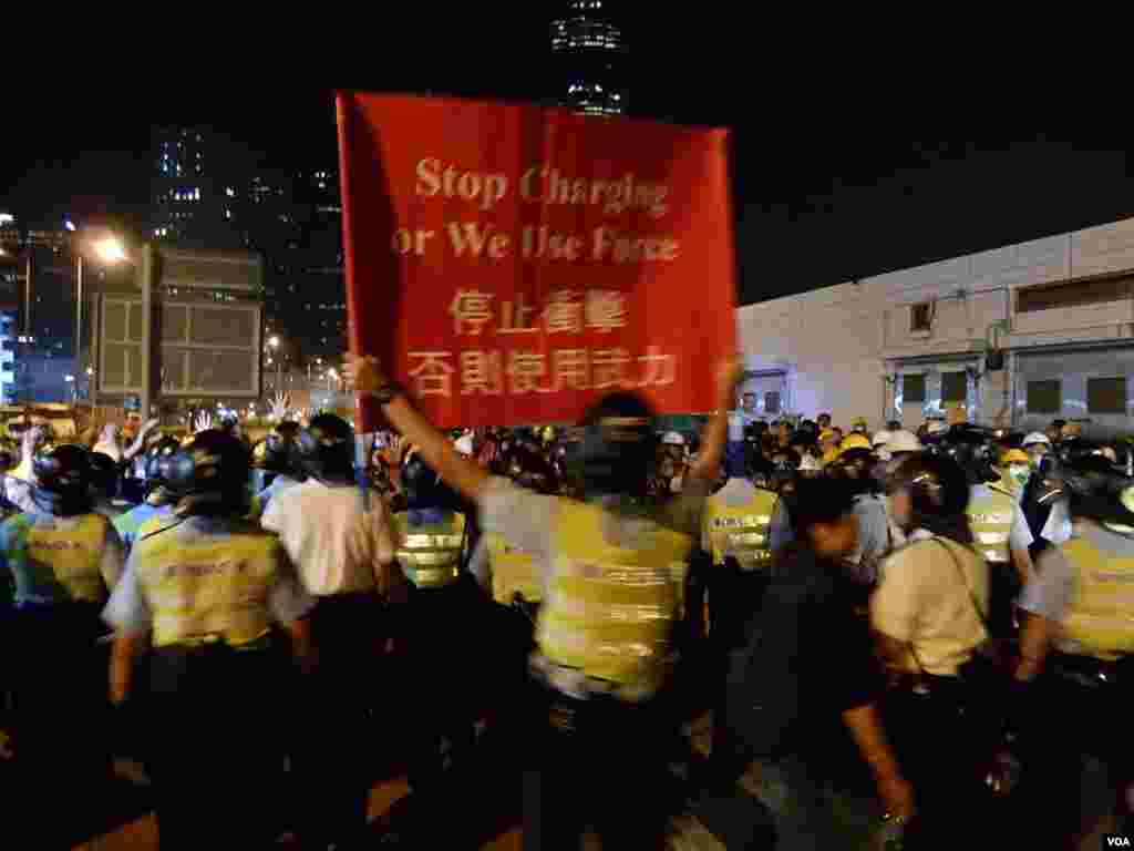 大批防穿上防暴裝備的警員高舉警告標語，驅散佔領龍和道的示威者