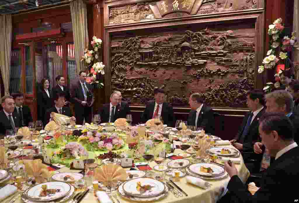 中国国家主席习近平，俄罗斯总统普京和外交部长拉夫罗夫（习近平右侧）在北京的 &ldquo;一带一路&rdquo;国际合作高峰论坛开幕式前的早餐会上交谈。王沪宁和外长王毅在场，另一位中国高官疑似栗战书（2017年5月14日）。