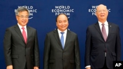 越南总理阮春福（中）、中国副总理胡春华（左）和世界经济论坛执行主席施瓦布在世界经济论坛东盟会议上合影。（2018年9月12日） 