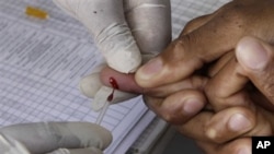 FILE - A patient undergoes a pin prick blood test inside a mobile healthcare clinic parked in South Africa. A simple blood test could determine longevity, according to new research.
