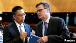 美國駐WTO大使謝伊(右)在瑞士日內瓦舉行的世界貿易組織（WTO）會議上與中國駐WTO大使張向晨交談。（2018年7月26日）