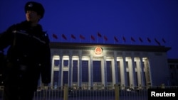 中國全國人民代表大會開幕前，一名警察在日出前守在北京的人民大會堂外。 (2025年3月5日)