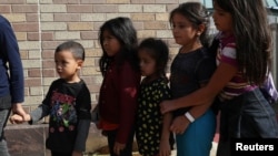 Children form a line as undocumented immigrant families are released from detention at a bus depot in McAllen, Texas, June 22, 2018. Experts say being separated from their parents can take a heavy toll on children.