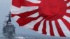 FILE - Japan Maritime Self-Defense Force (JMSDF) escort ship "Kurama," left, navigates behind destroyer "Yudachi," with a flag, during a fleet review in water off Sagami Bay, south of Tokyo.