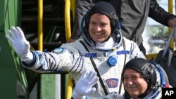 美國太空人費舍爾(左)和俄羅斯太空人尤奇辛在哈薩克斯坦登上太空船 (資料圖片)