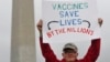 Ben Prickril poses for a portrait with a sign that reads "Vaccines Save Lives By The Millions" at the March for Science event in Washington, April 22, 2017.