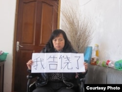 陈庆霞手持“我告饶了”牌子（图片由支持陈庆霞团体提供）