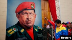 委內瑞拉副總統馬杜洛在總統查韋斯的畫像前高舉拳頭