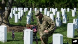 在华盛顿郊区的阿灵顿国家公墓，号称老卫队的美国陆军第三步兵团的一位军人把小型国旗插在每一座墓碑前，他短暂停下来，悼念一名阵亡者（2018年5月24日）。 