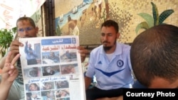 穆斯林兄弟会的医生拿着的报纸上有死于军警冲突的抗议者照片
