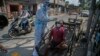 A health worker takes a nasal swab sample of a cartpuller during random testing for COVID-19 in a market in Gauhati, India.