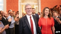 ​ຜູ້​ຖືກ​ເລືອກ​ເປັນ​ນາ​ຍົກ​ລັດ​ຖະ​ມົນ​ຕີ​ຂອງ ອັງ​ກິດ ຄົນ​ຕໍ່​ໄປ ທ່ານ ເຄຍ ສ​ຕາ​ເມີ ແລະ ພັນ​ລະ​ຍາ ທ່າ​ນ​ນາງ ວິກ​ຕໍ​ເຣຍ, ໄດ້​ຮັບ​ການ​ຕ້ອງ​ຮັບ​ເວ​ລາ​ທີ່​ທ່ານ​ເດີນ​ທາ​ງ​ຮອດ​ທຳ​ນຽບ​ປະ​ທາ​ນາ​ທິ​ບໍ​ດີ , 5 ກໍ​ລະ​ກົດ 2024.