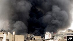 3月19日在阿勒颇，叙利亚政府发动的轰炸使建筑物冒起滚滚黑烟