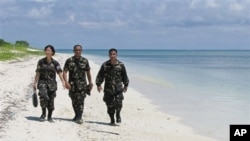 这张2008年5月的资料照片显示菲律宾军人在卡拉扬群岛中的帕加萨岛(中国称中业岛)的沙滩上轻松散步