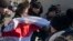 Офицеры белорусской полиции задерживают женщину, развернувшую прежний флаг Беларуси. Минск, Беларусь. 25 марта 2018 г.