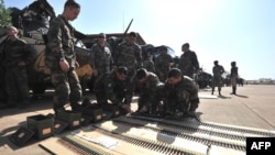 法国士兵1月16日在部署之前，在巴马科空军基地准备他们的弹药
