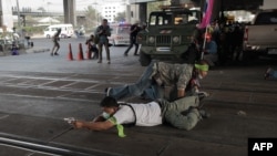 2月1日泰国曼谷，支持选举的人士边隐蔽边用枪瞄准对立派抗议人士