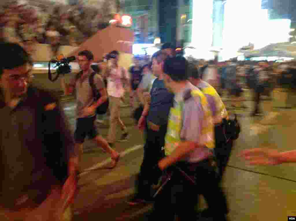 被指控欧打示威者的反占中人士被声援学生市民包围并被警方护送离开现场(美国之音海彦拍摄)