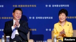 2014年7月4日中国国家主席习近平（左）和韩国朴槿惠在首尔出席韩国中国投资论坛