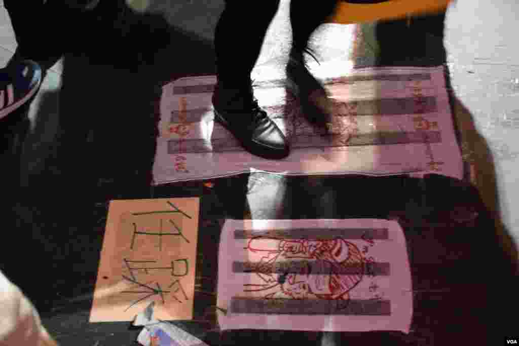 香港民主党在维园年宵摊位的地上贴上两块恶搞梁振英抹地布