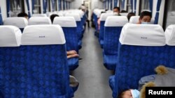 湖北武昌火車站裡戴著口罩的旅客在火車車廂裡休息。 （2020年4月8日）