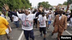 弗格森警察槍擊案死者布朗的父親（中）與抗議者一道遊行紀念該事件一週年。