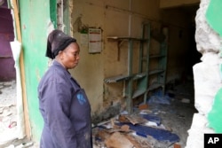 Millicent Otondo stands in front of her demolished shop in Mathare in Nairobi, on May 8, 2024. The Kenyan government ordered the evacuation of people from flood-prone areas and the demolition of buildings within 30 meters of rivers.