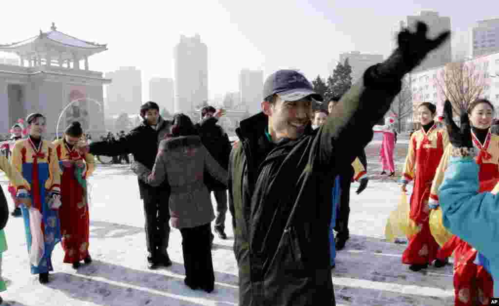 2012年12月12日，青少年在平壤大剧院前跳舞庆祝火箭发射成功。