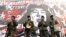 Chinese actors dressed as workers perform in front of a portrait of "People's Hero" Lei Feng to urge people to learn from the model soldier during a performance in Beijing March 1, 2003. 