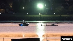 Спасатели рядом с обломками вертолета Black Hawk, упавшего в реку Потомак после того, как он столкнулся с рейсом American Eagle 5342, который приближался к национальному аэропорту Рейгана в Вашингтоне, 30 января 2025 года. 